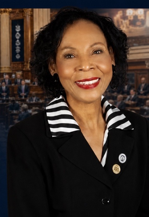 Representative Pat Moore smiling, standing before the Louisiana House chamber